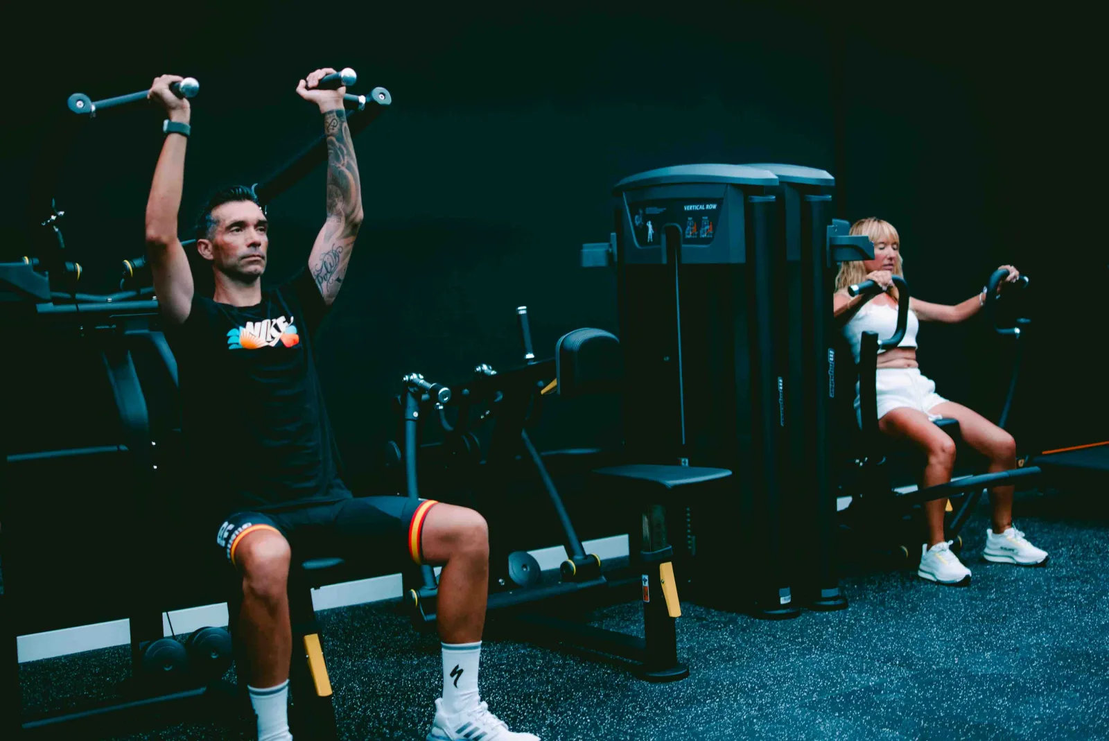 Pareja entrenando press de hombros en el gimnasio Kenkatsu